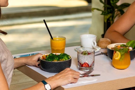 Two woman eating tasty chicken salads with dessert